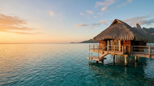 Serene overwater bungalow suspended above turquoise lagoon with warm sunset light creating peaceful atmosphere for dream vacation